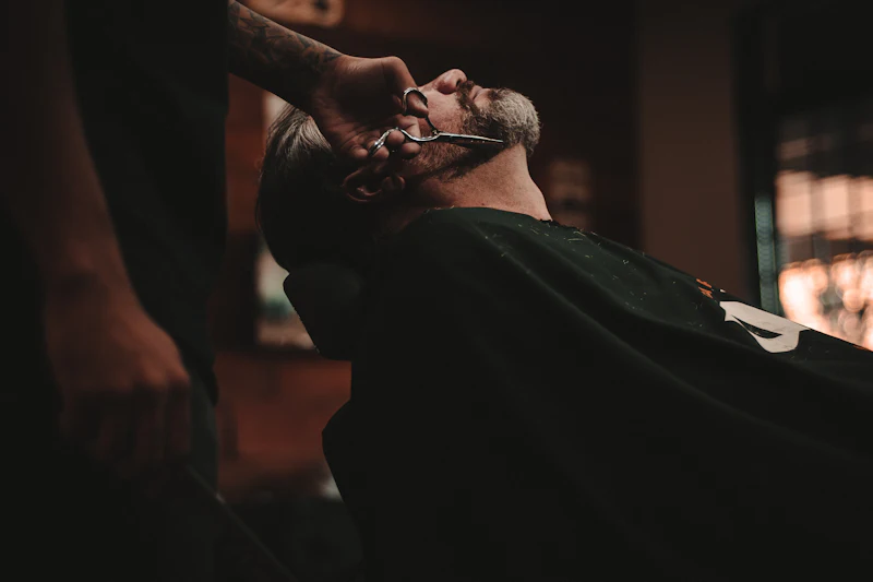 Barbeiro fazendo a barba de um cliente na cadeira