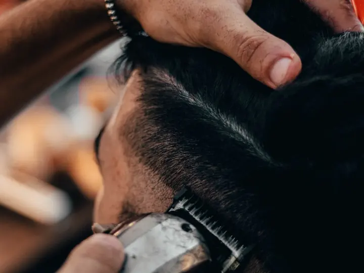 Mãos ajustando o cabelo com pente durante o acabamento